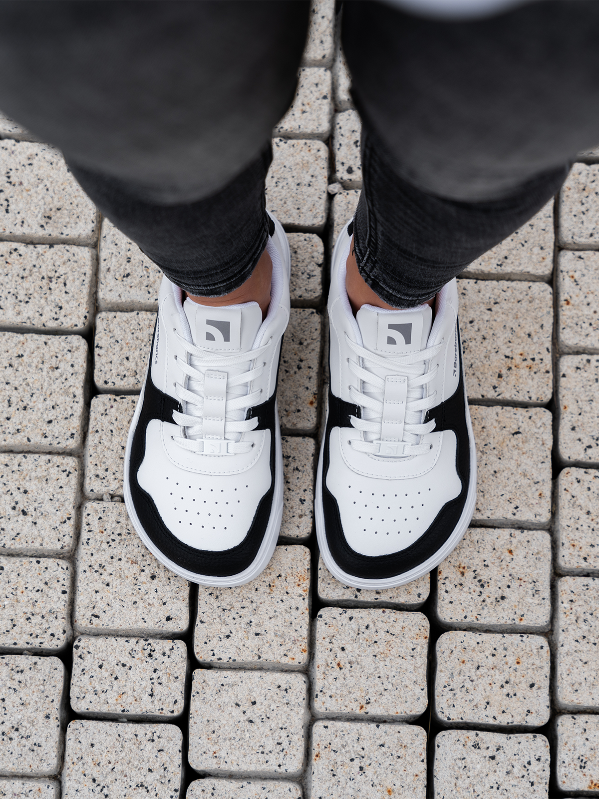 zing white and black leather na osobi odozgo dok stoji