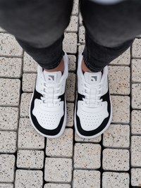 zing white and black leather na osobi odozgo dok stoji