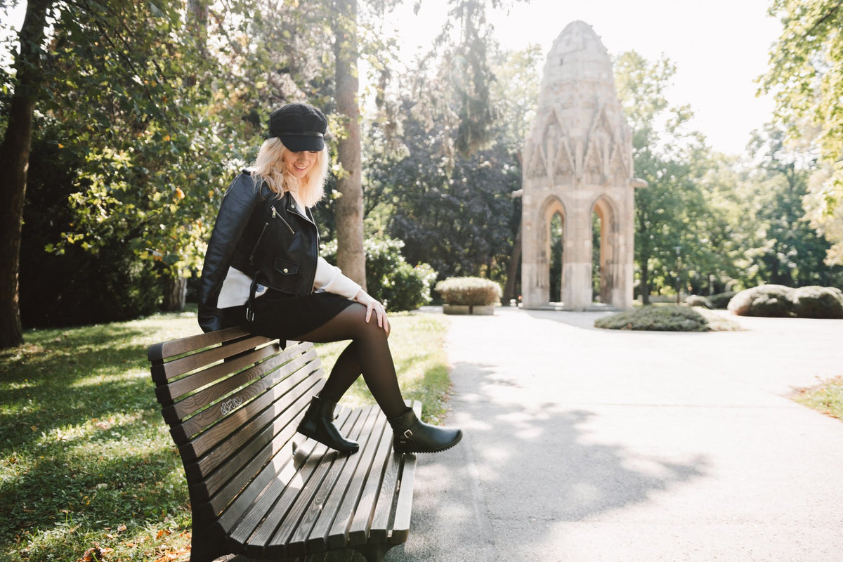 Lifestyle fotografija barefoot cizama Diva crne osoba sedi na klupi u parku