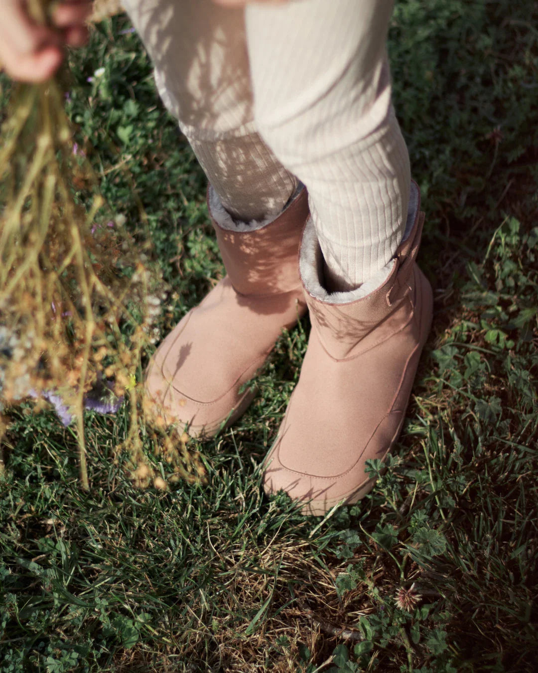 Lifestyle fotografija barefoot cizama Siberia roze osoba stoji na travi pored sena