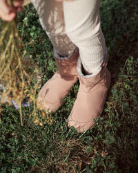 Lifestyle fotografija barefoot cizama Siberia roze osoba stoji na travi pored sena