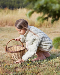 Lifestyle fotografija barefoot cizama Siberia roze dete cuci na travi pored korpe