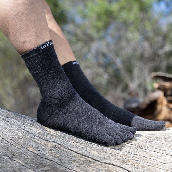 Detalj stopala u Injinji Liner Crew Wool Slate carapama na kamenju