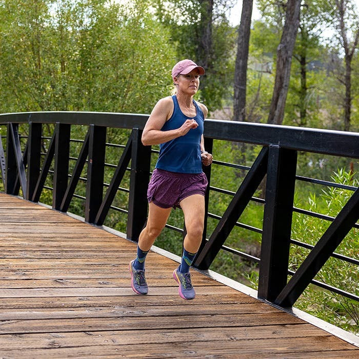 Model nosi Injinji Run Lightweight Crew Glow carape tokom trcanja u prirodi