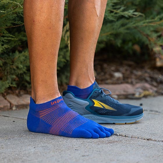 Model stoji u Injinji Run Lightweight No-Show Sapphire carapama na otvorenom