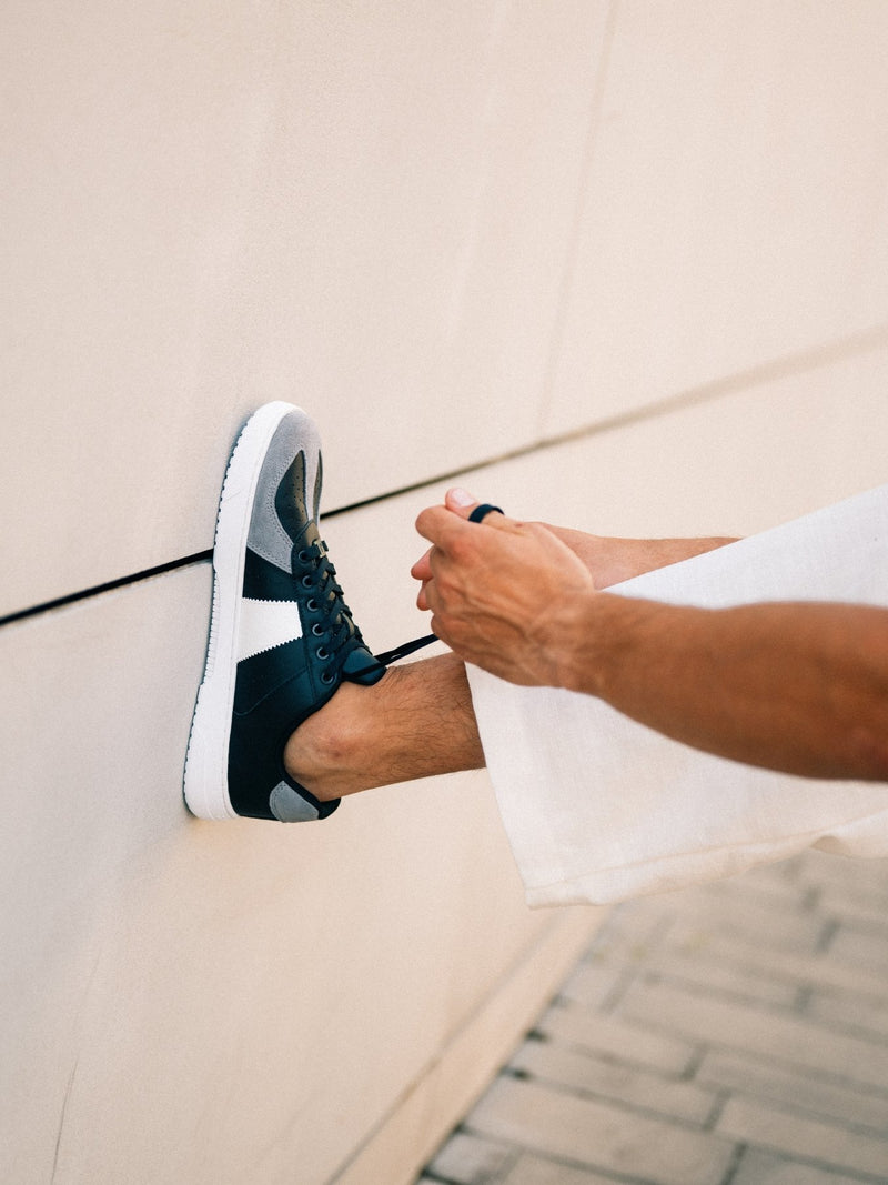 Barebarics Icara crno siva – lifestyle fotografija naslonjena patika na zidu