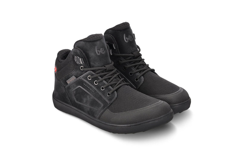 Arctic Edge All Black barefoot čizme par položen pod blagim uglom na beloj pozadini