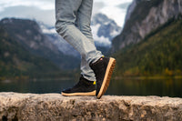 Arctic Edge crne barefoot čizme osoba zakoračuje na stenu pogled na đon