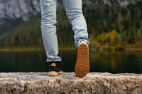 Arctic Edge crne barefoot čizme osoba hoda po kamenitom tlu pogled sa strane