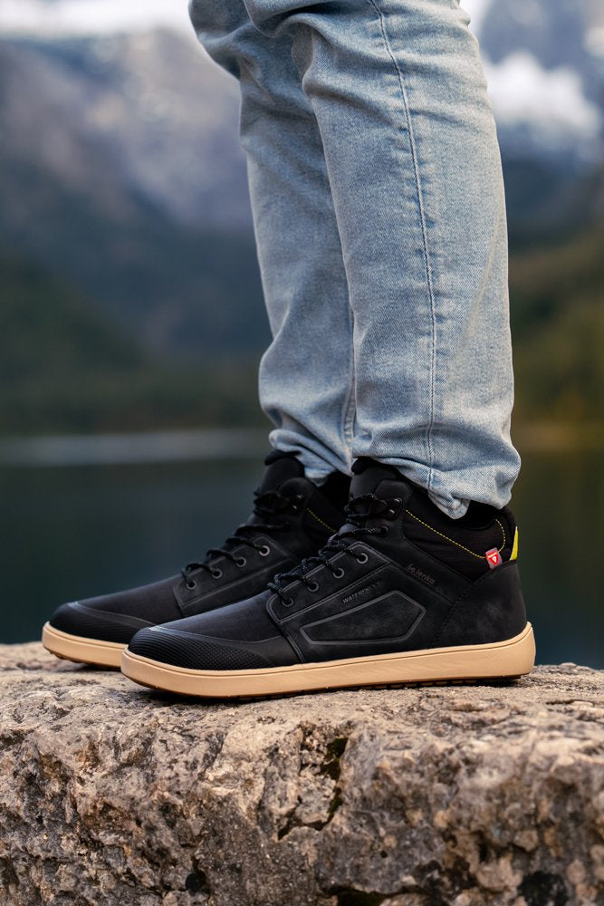 Arctic Edge crne barefoot čizme na nozi pogled sa strane na kamenu
