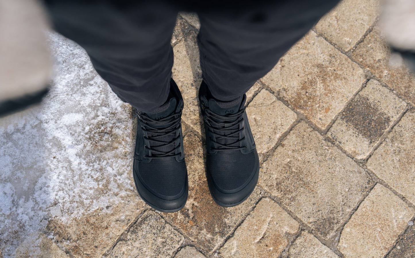 Arctic Edge All Black barefoot čizme pogled odozgo na par obuće na kamenju