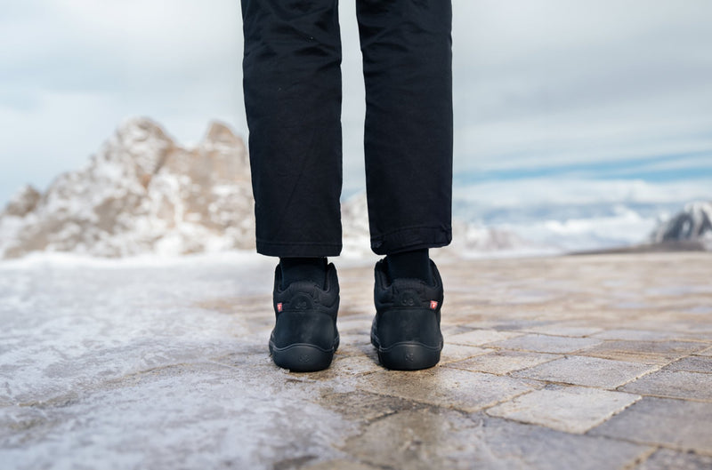 Arctic Edge All Black barefoot čizme osoba stoji na snežnoj podlozi snimak nogu