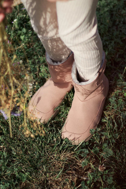 Lifestyle fotografija barefoot cizama Siberia roze osoba stoji na travi pored sena