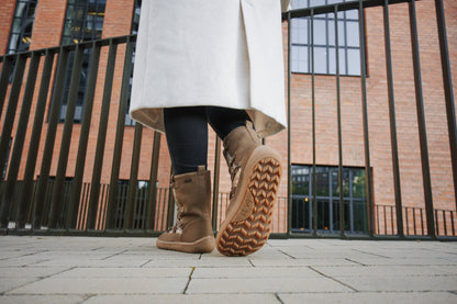 Lifestyle fotografija barefoot cizama Snowfox zlatne osoba stoji ispred ograde